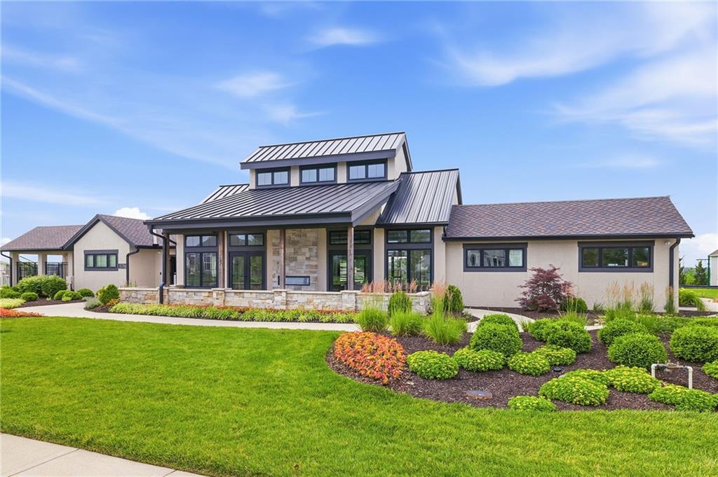 The Mission Ranch clubhouse, with stone accents, a standing-seam metal roof, and manicured landscaping