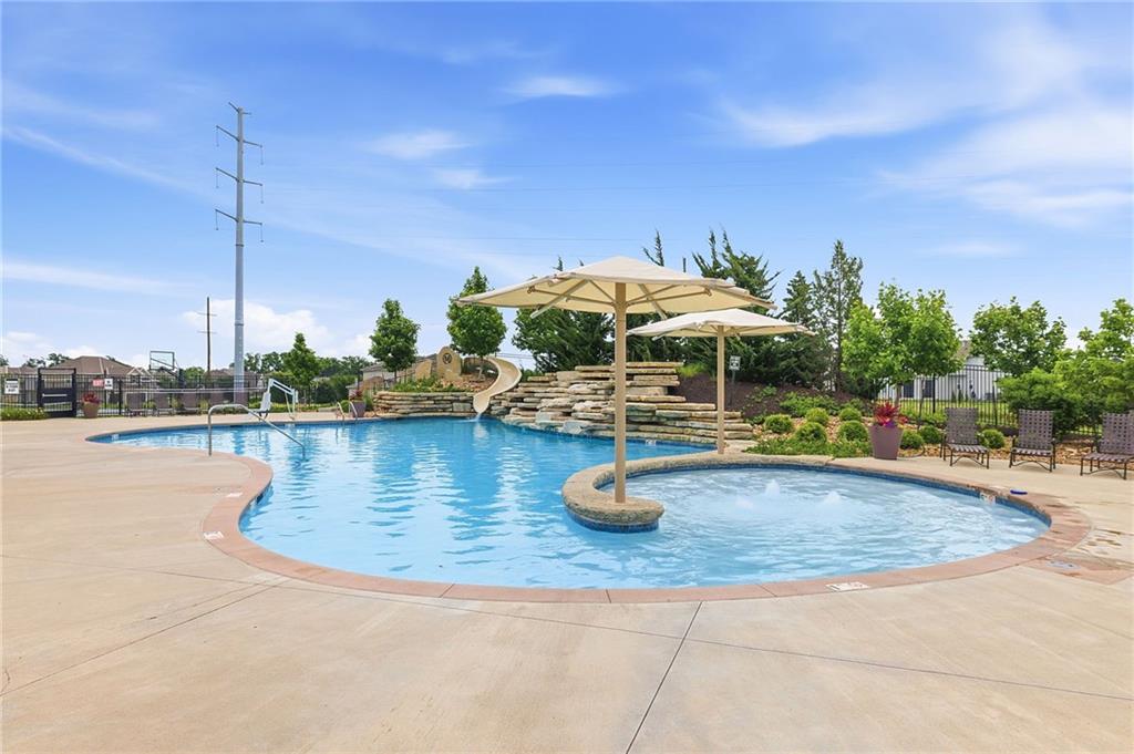 The Mission Ranch resort pool, with a stone waterslide, bubbler fountains, and shaded lounge seating
