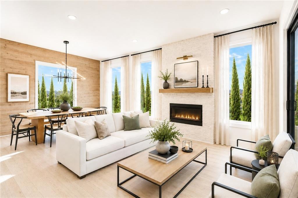 Hearth room with a linear gas fireplace in white brick, a wood-plank accent wall, a dining table with wishbone chairs, and tall windows framed by sheer curtains